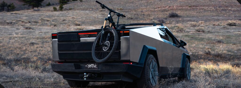 Tesla Cybertruck driving through desert landscape with referral bonus benefits displayed