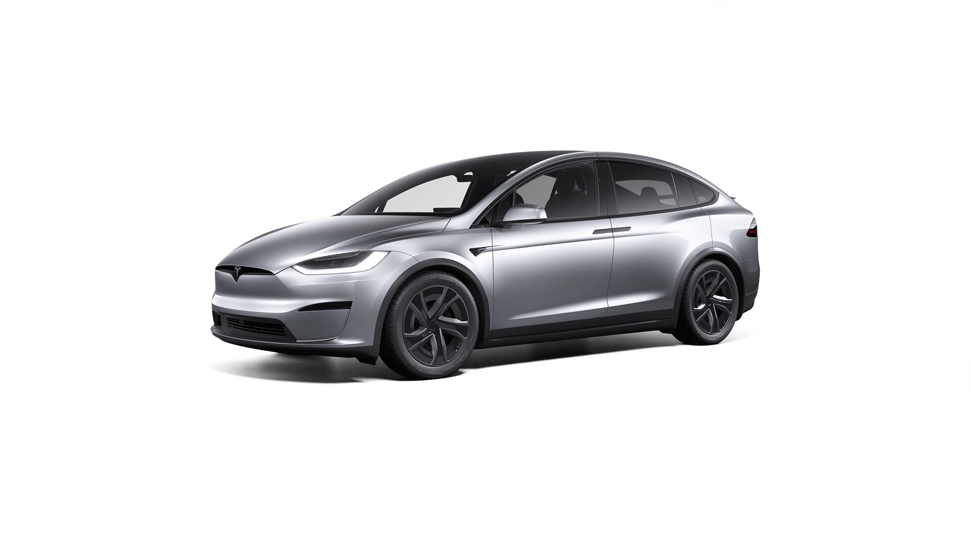 A white Tesla Model Y parked on a scenic mountain road with lush green hills in the background.